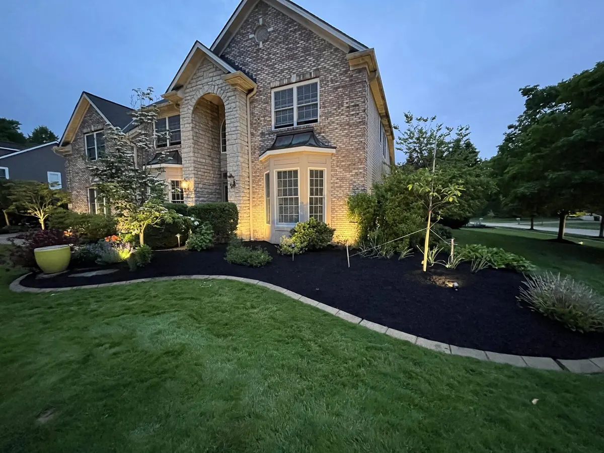 Stone mansion at dusk with full landscape install