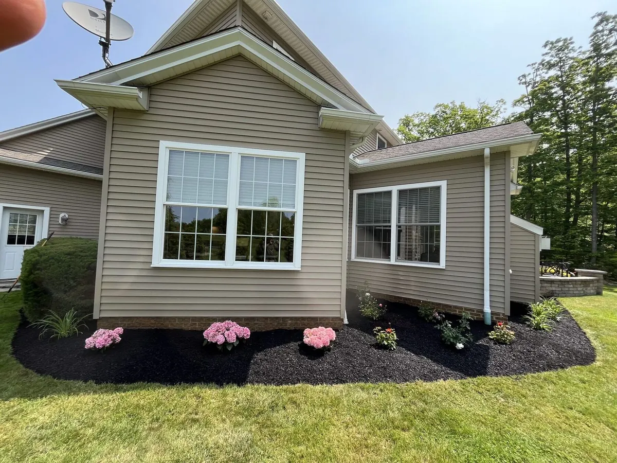 Dark mulch installation along home siding