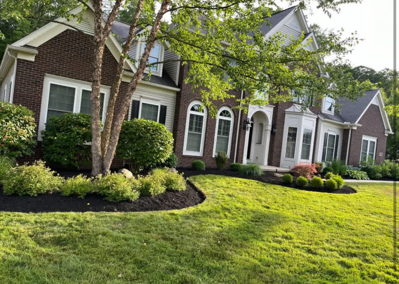 Freshly mulched landscape beds at a red brick home in Bainbridge, Ohio