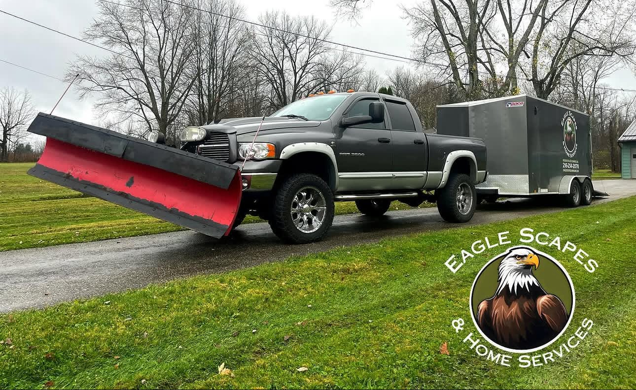 Eagle Scapes truck with snow plow attached and branded trailer ready for winter service in Northeast Ohio