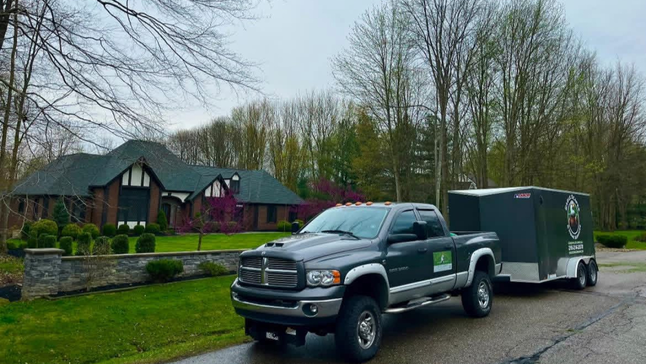 Eagle Scapes truck and trailer parked at a Tudor-style home before a landscape job in Bainbridge, Ohio